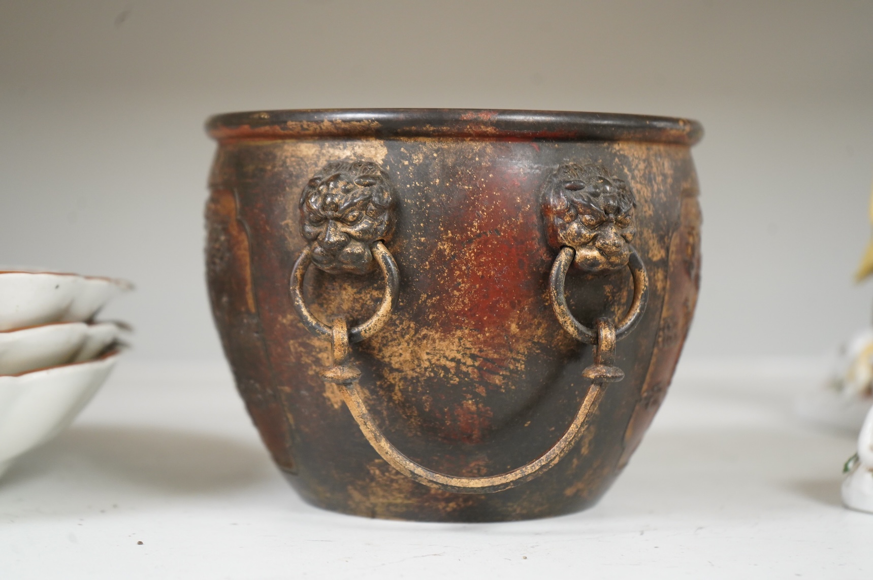 A Chinese partially gilt bronze censer, decorated in relief with twin handles, 16cm in diameter